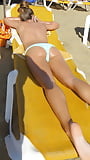 Oiled dark blonde babe on sunbed on the beach (11/12)